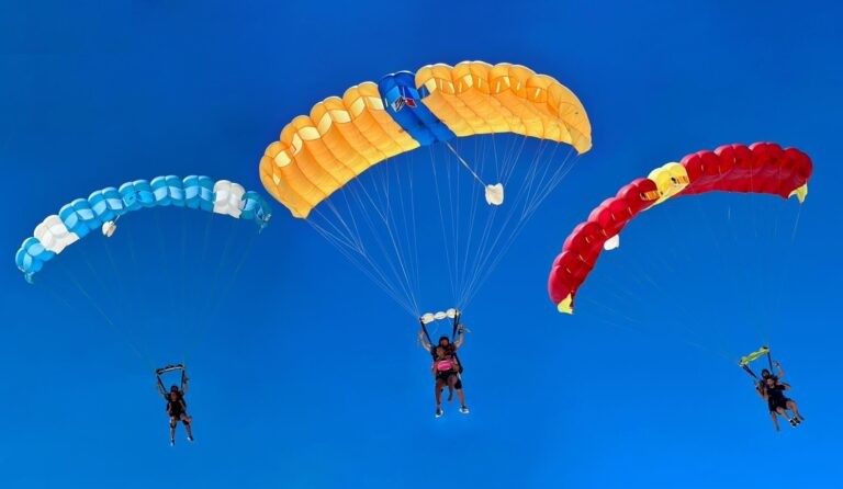 Three skydivers with open parachutes in the sky over Zanzibar